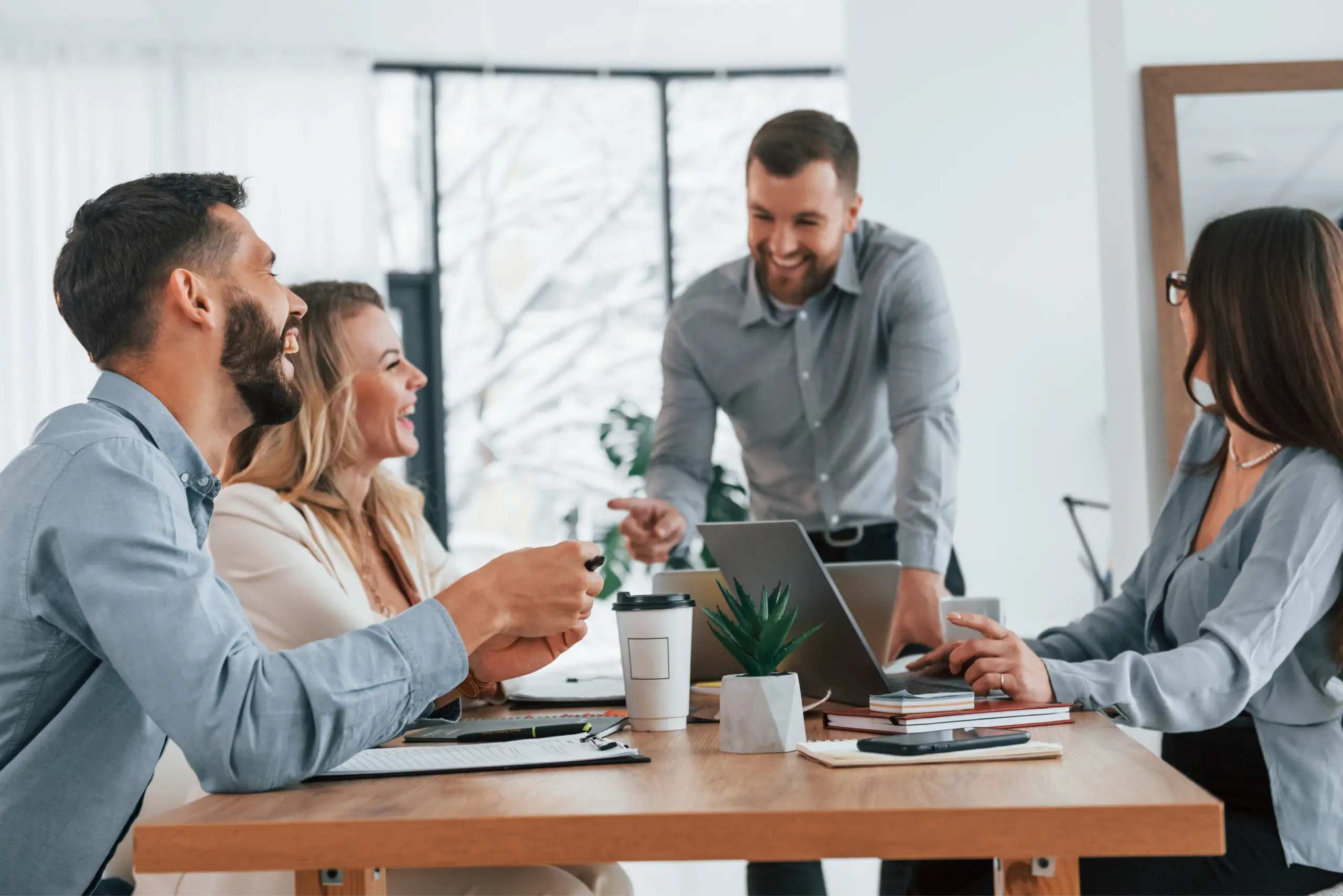 Mitarbeiter in einer Teambesprechung im Büro, die gemeinsam Arbeitsabläufe und die interne Kommunikation abstimmen.
